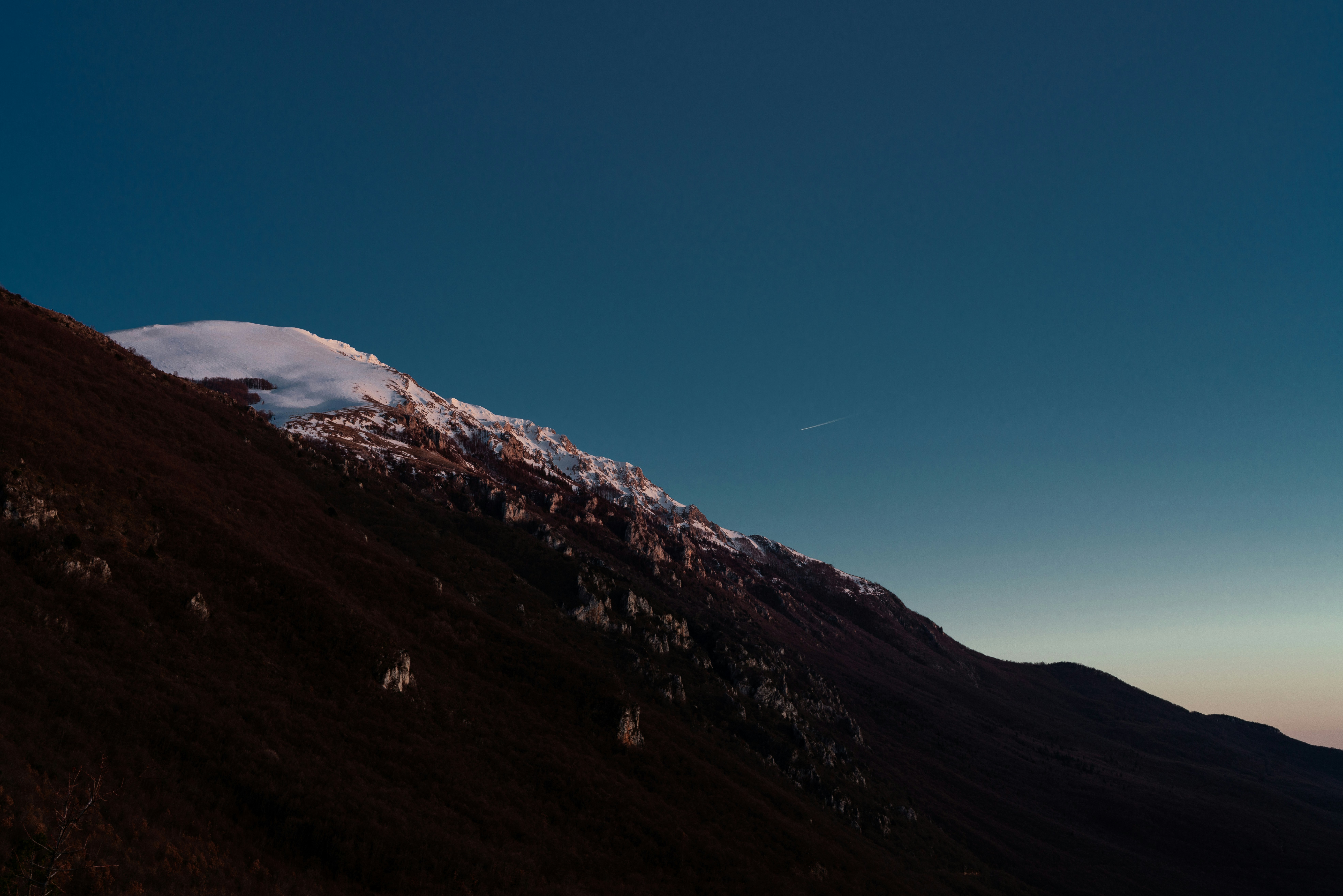 澄んだ青空を背景に雪を頂く山頂