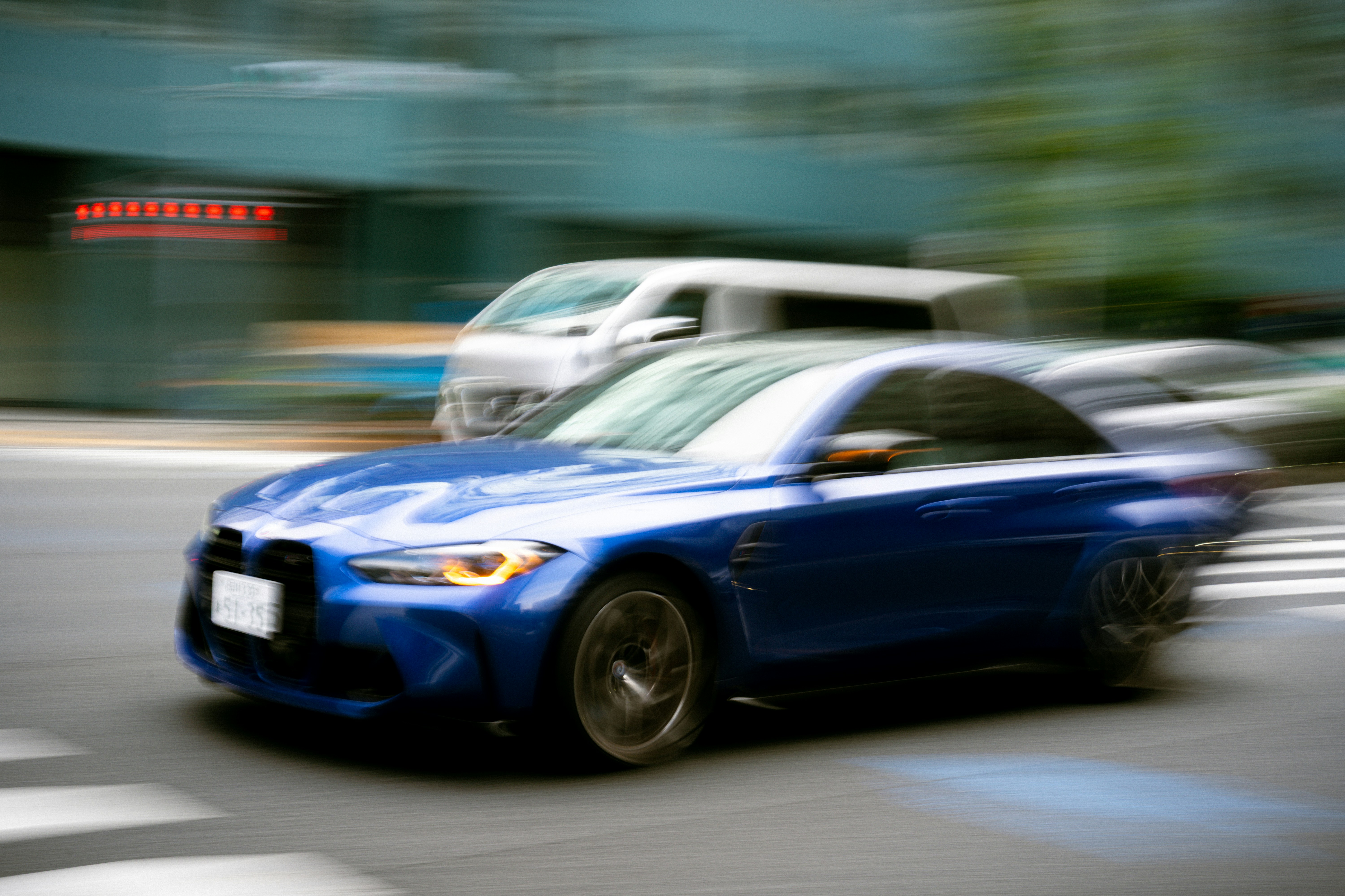 Coche azul acelerando por una calle de la ciudad