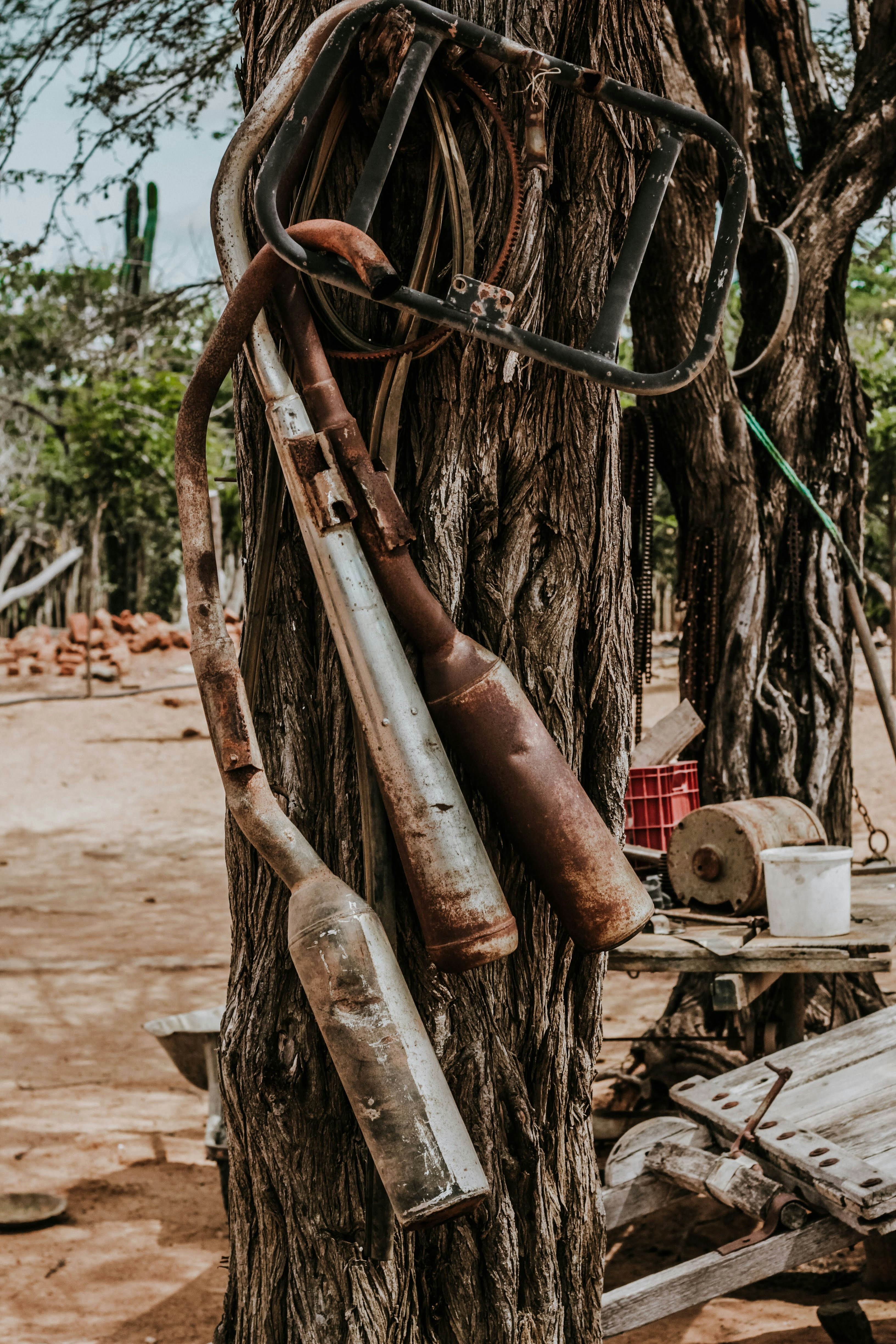 Rostige Auspuffrohre hängen an einem Baumstamm