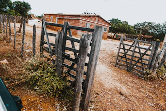 Rustic wooden gates in a dry, rural landscape.