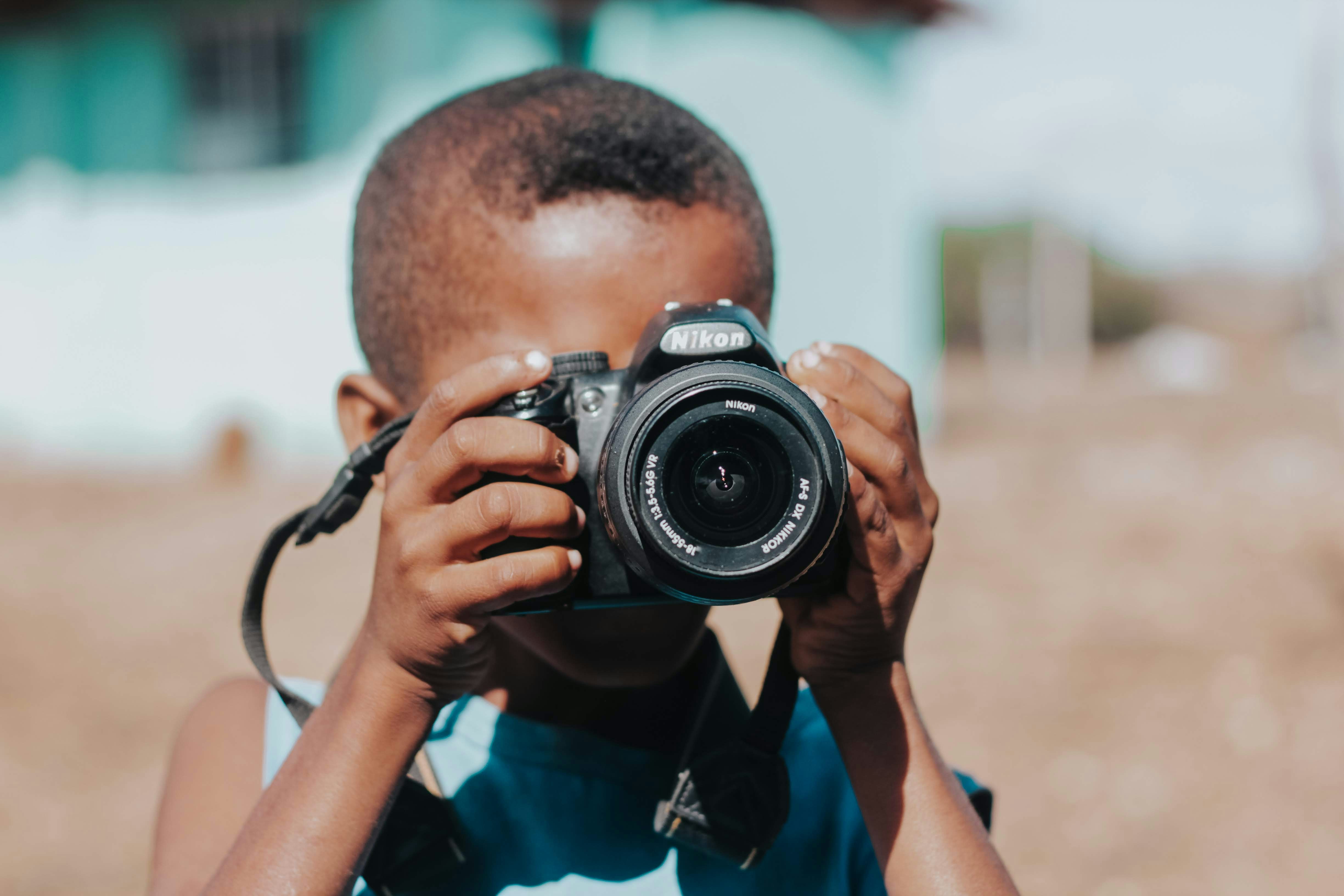 Young boy holding a camera and taking a picture