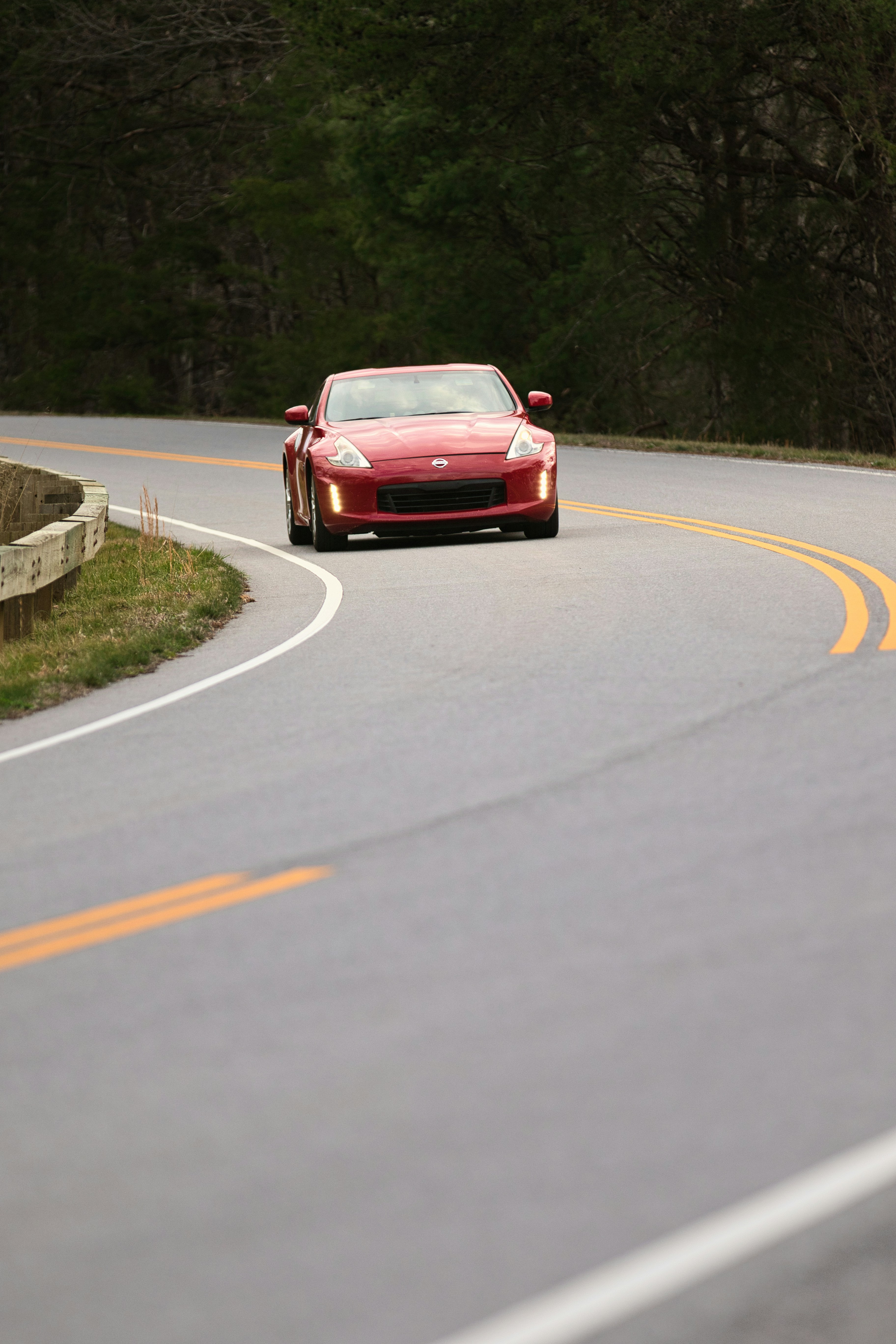 Voiture de sport rouge roulant sur une route sinueuse