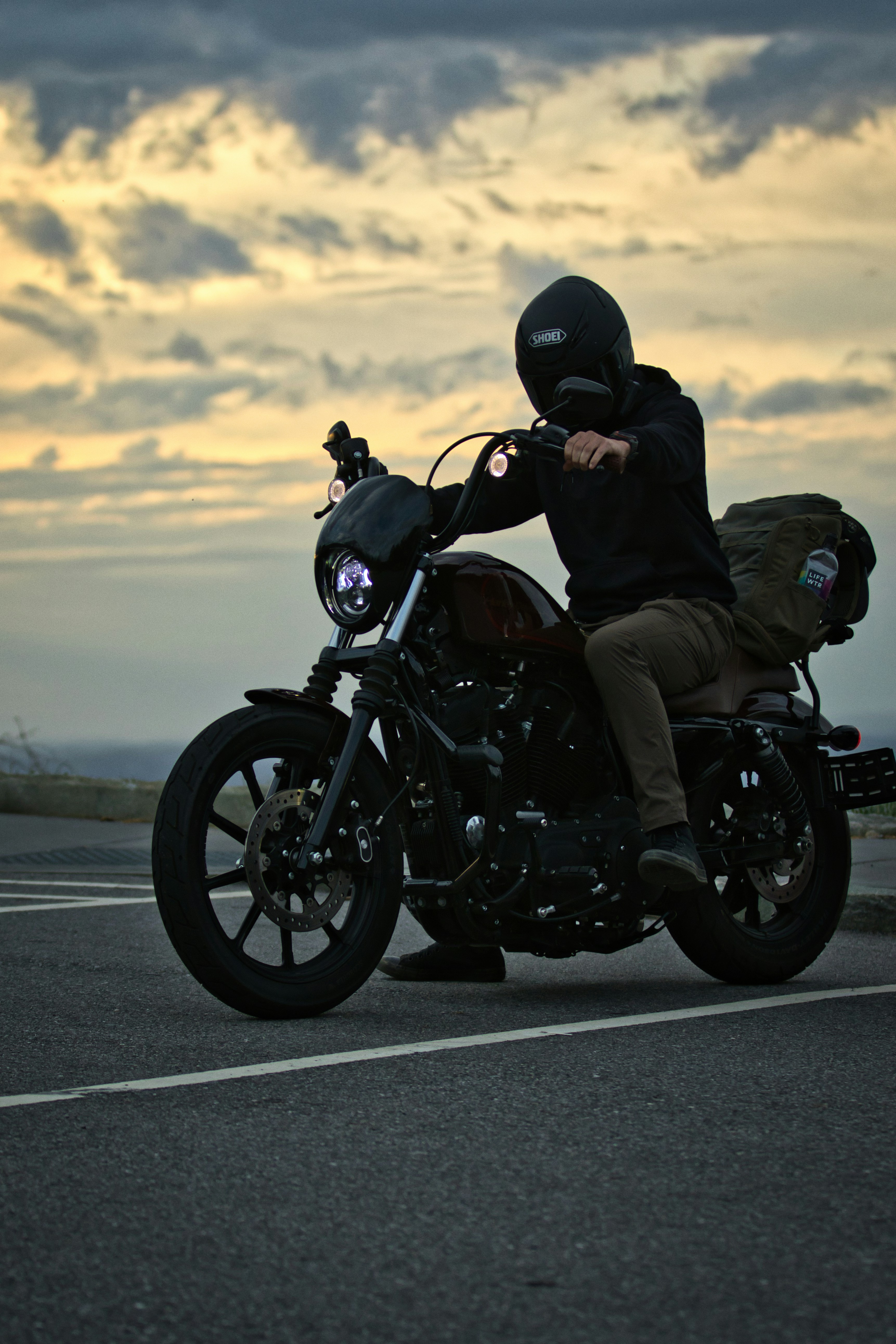 Personne casquée roulant à moto près de l’océan.
