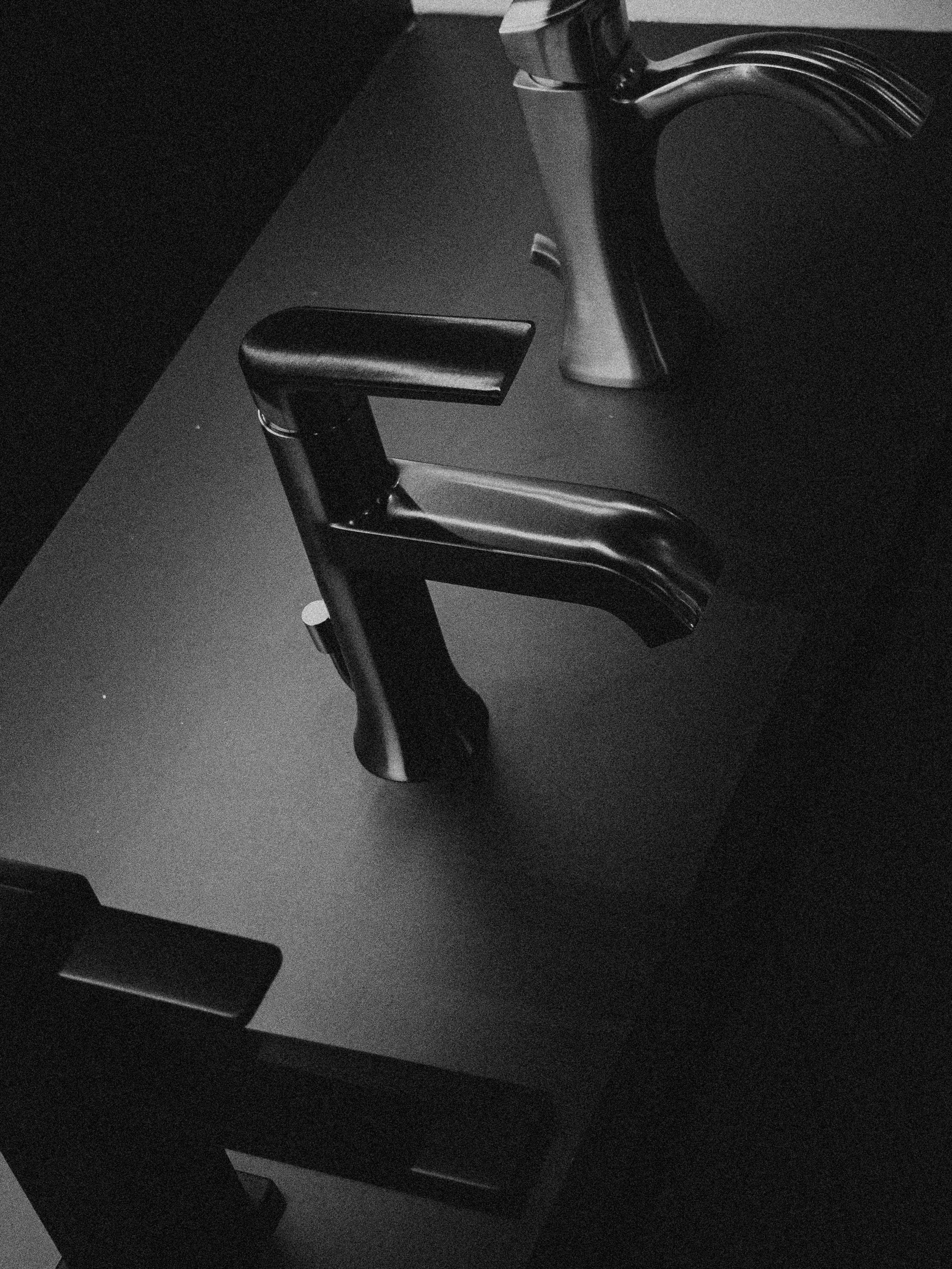 暗い表面に展示された現代の蛇口