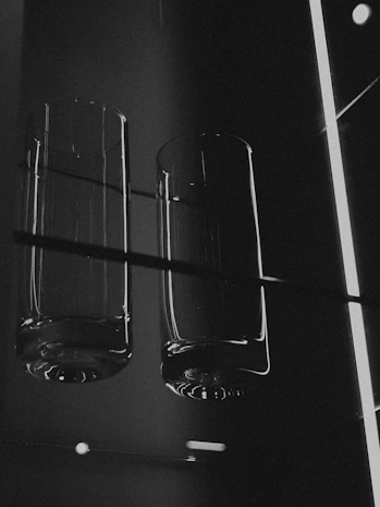 Two empty glasses on a shelf