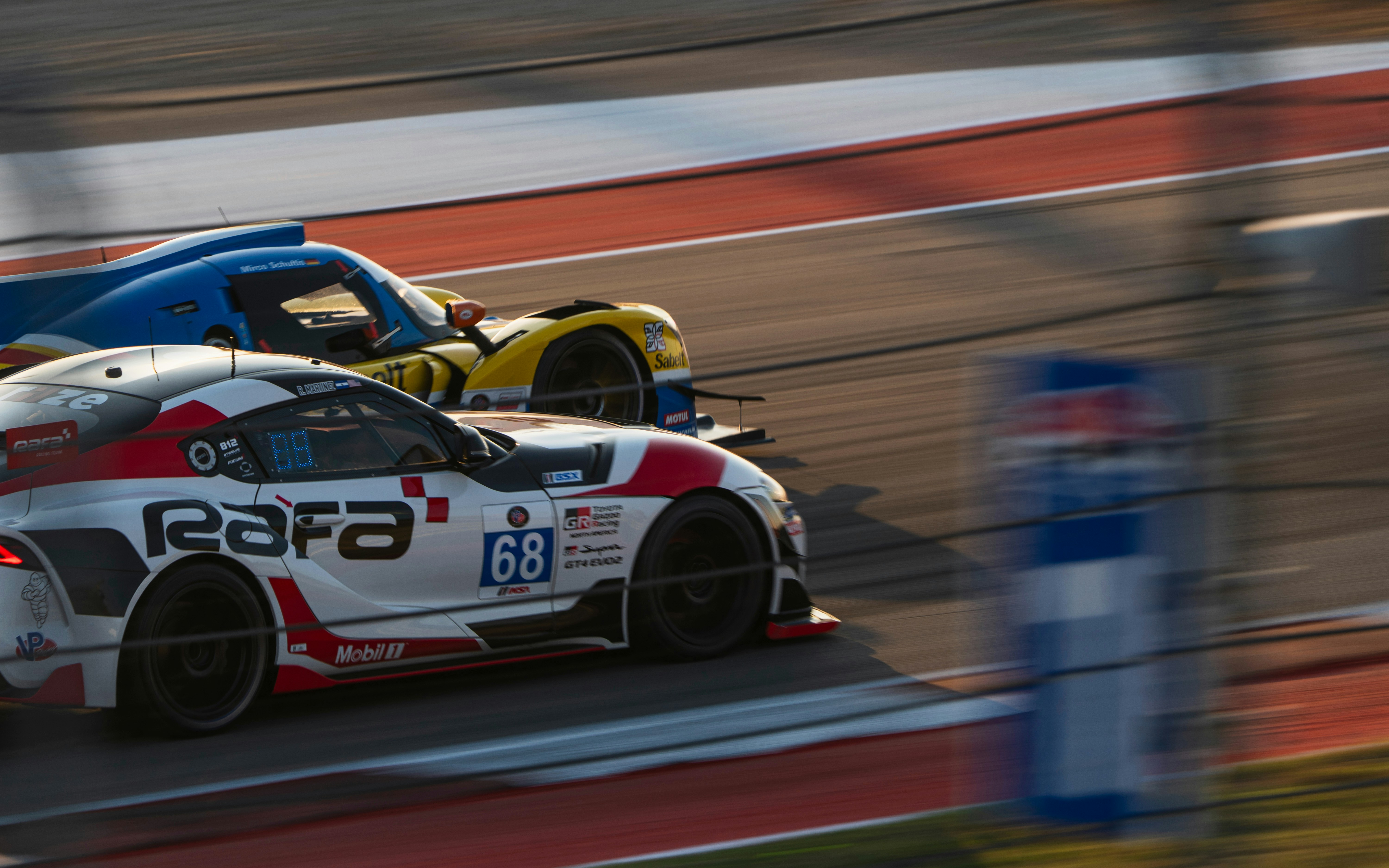 Two race cars competing on a track.