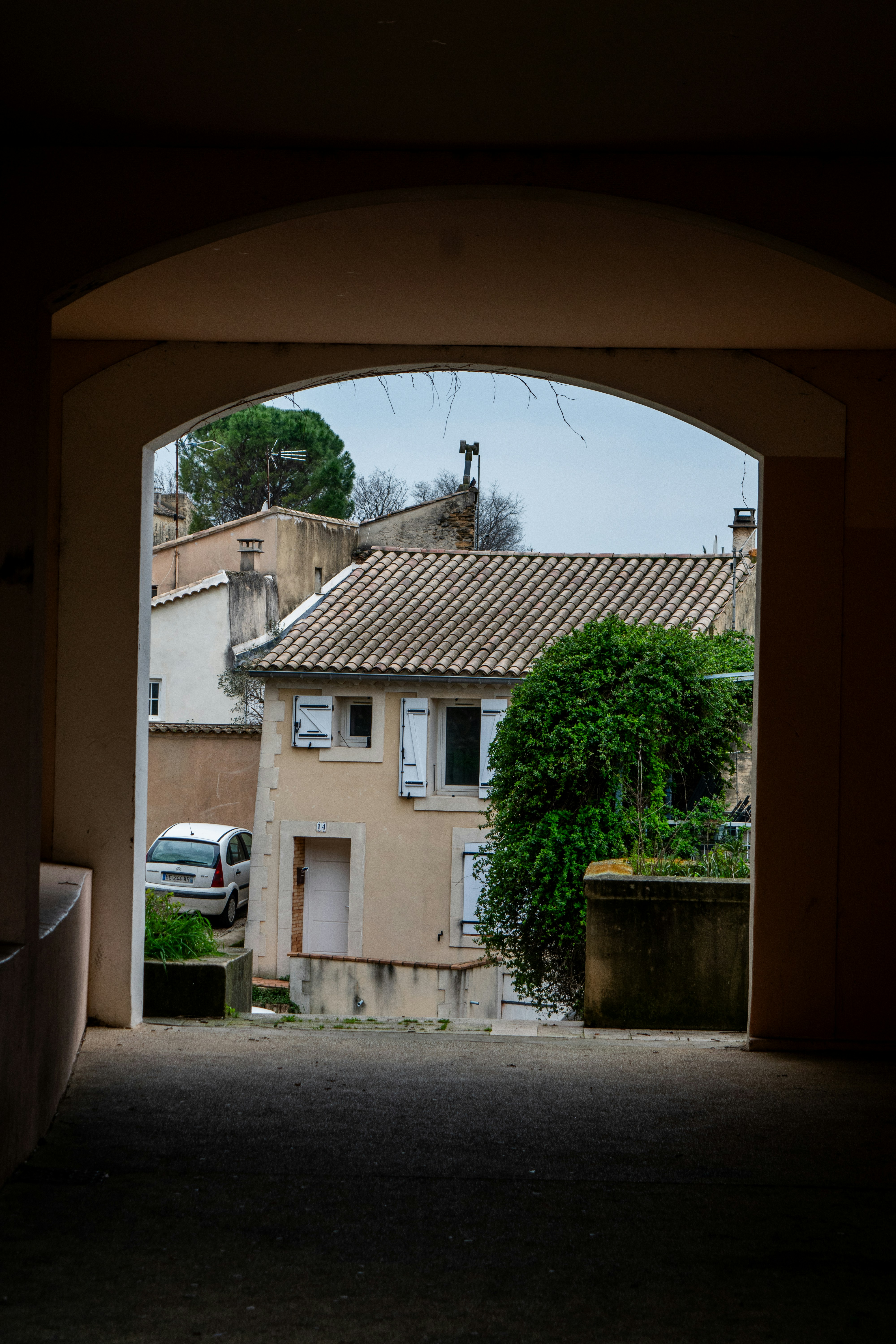 View through an archway of a quaint european village street.