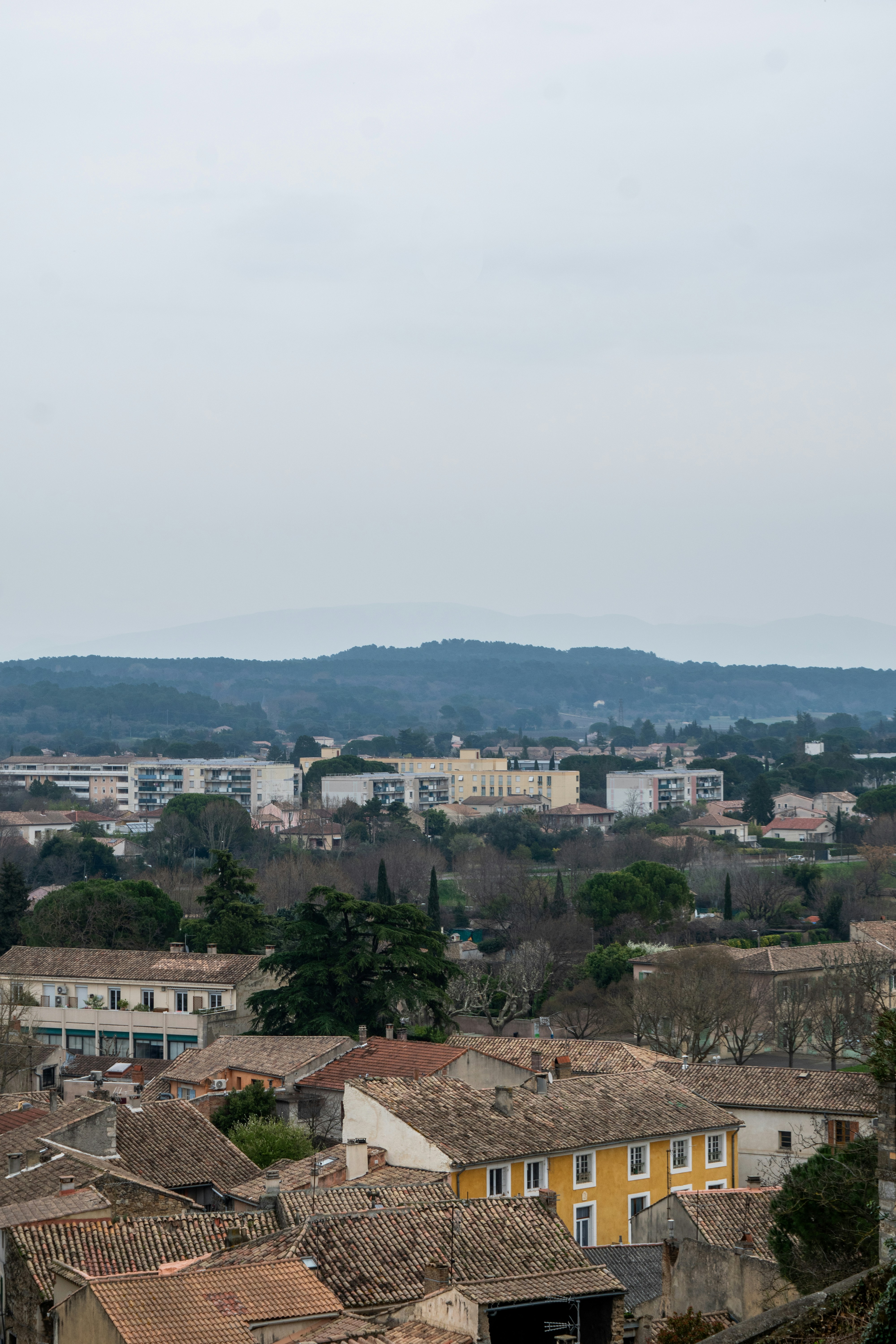 Overcast view of a european town with distant hills.