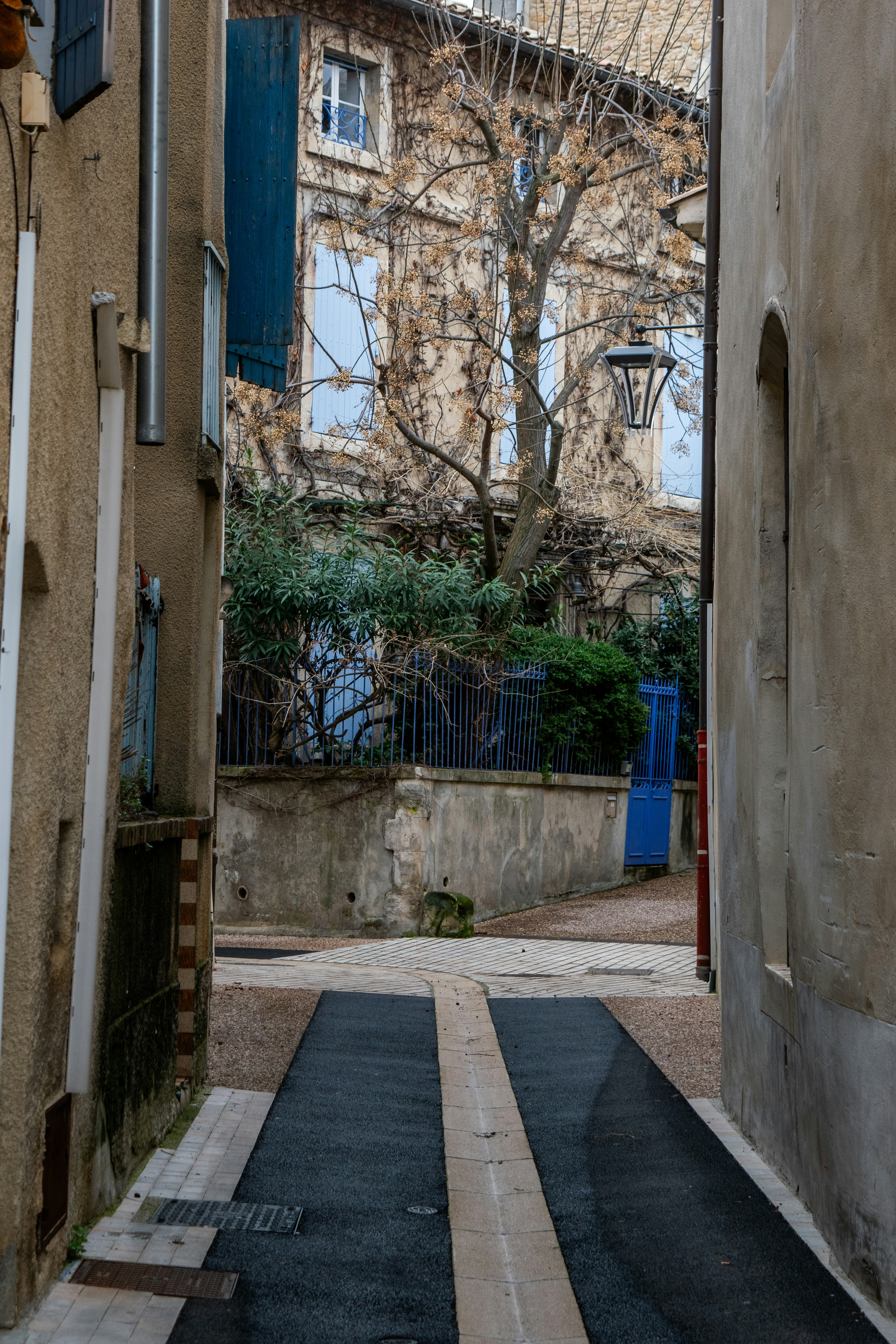 Narrow european alleyway with old buildings and blue shutters