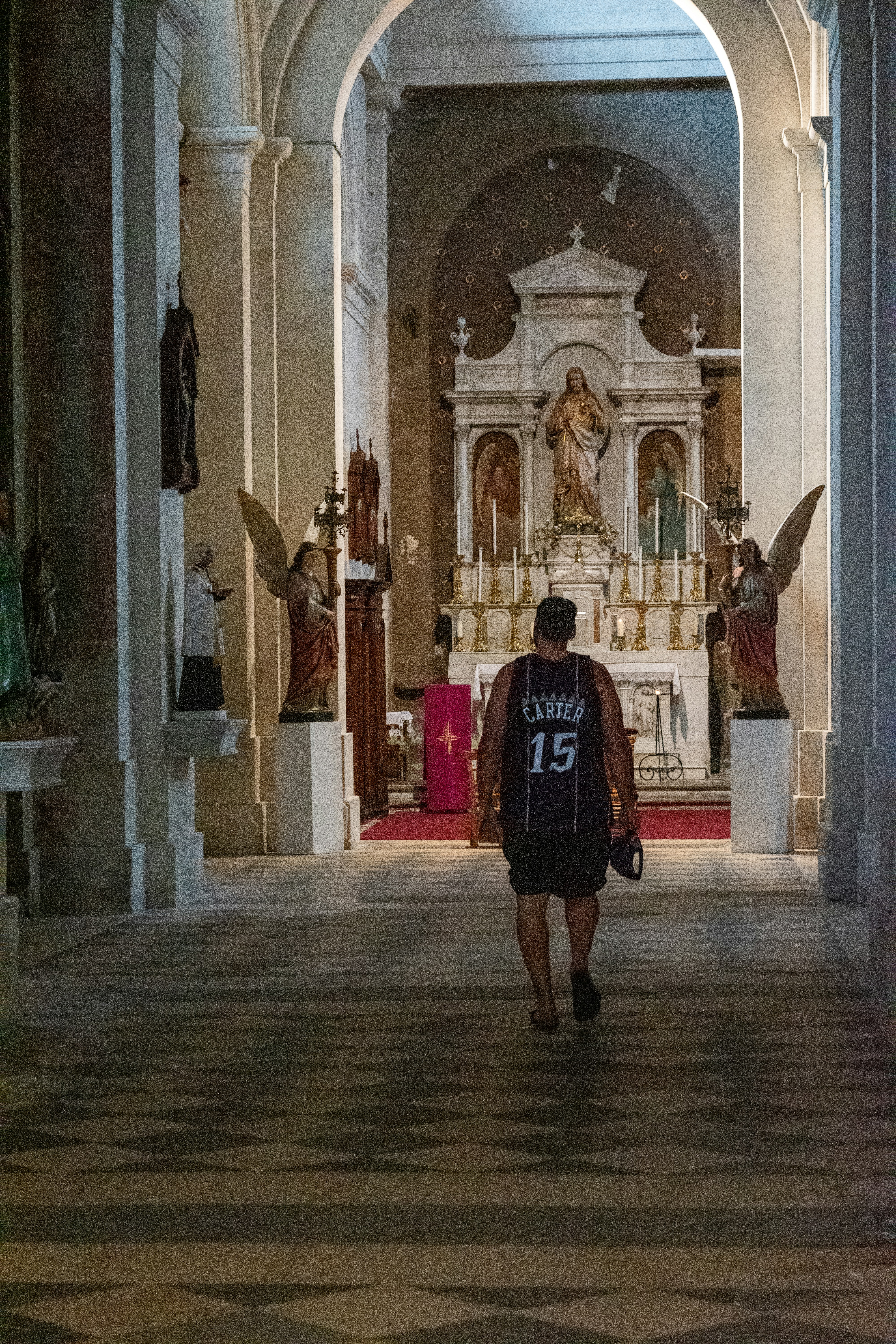 Man walks towards altar in ornate church interior.