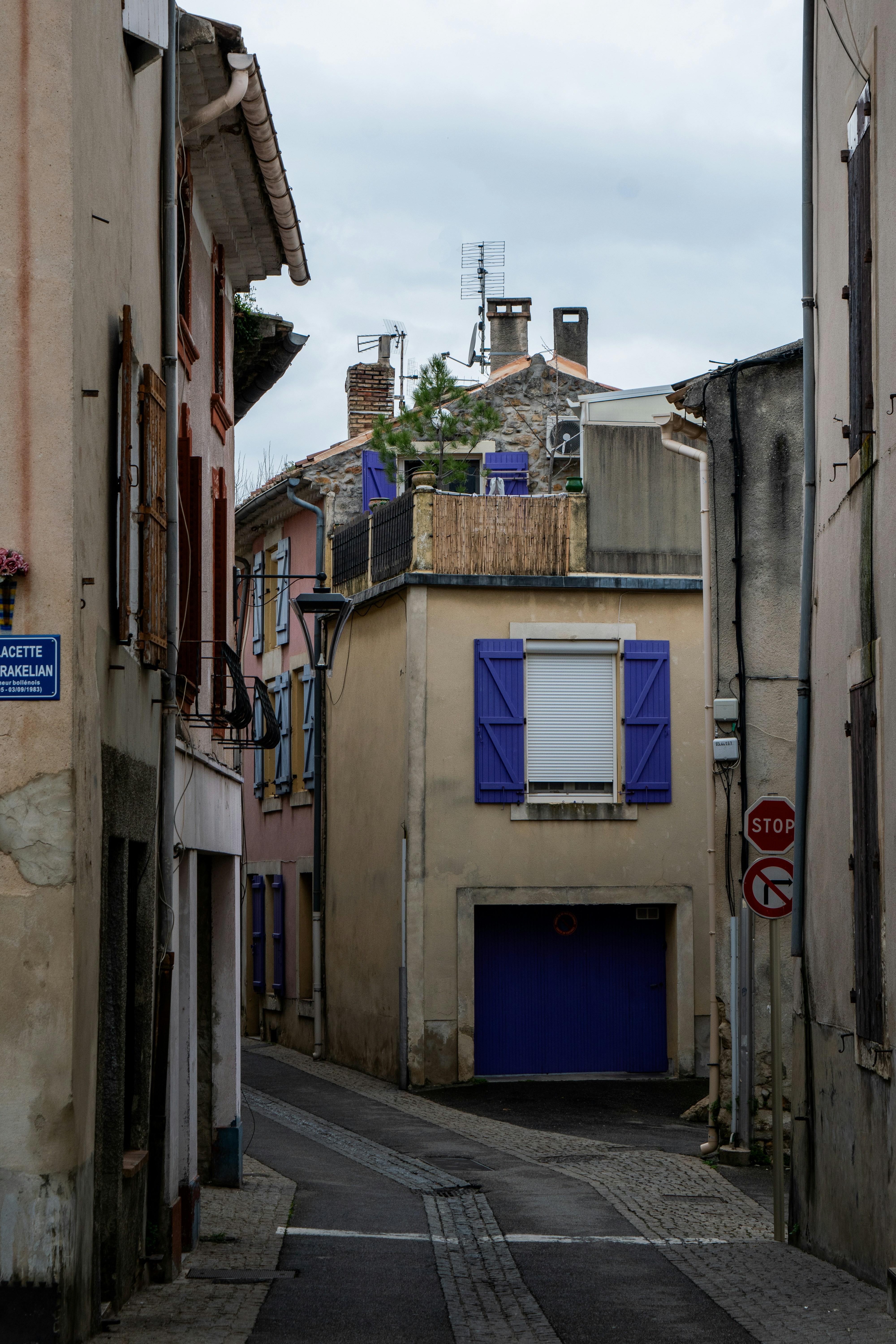 Narrow street with colorful buildings and purple shutters