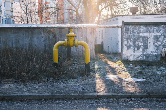 Yellow gas pipe with valve on concrete wall