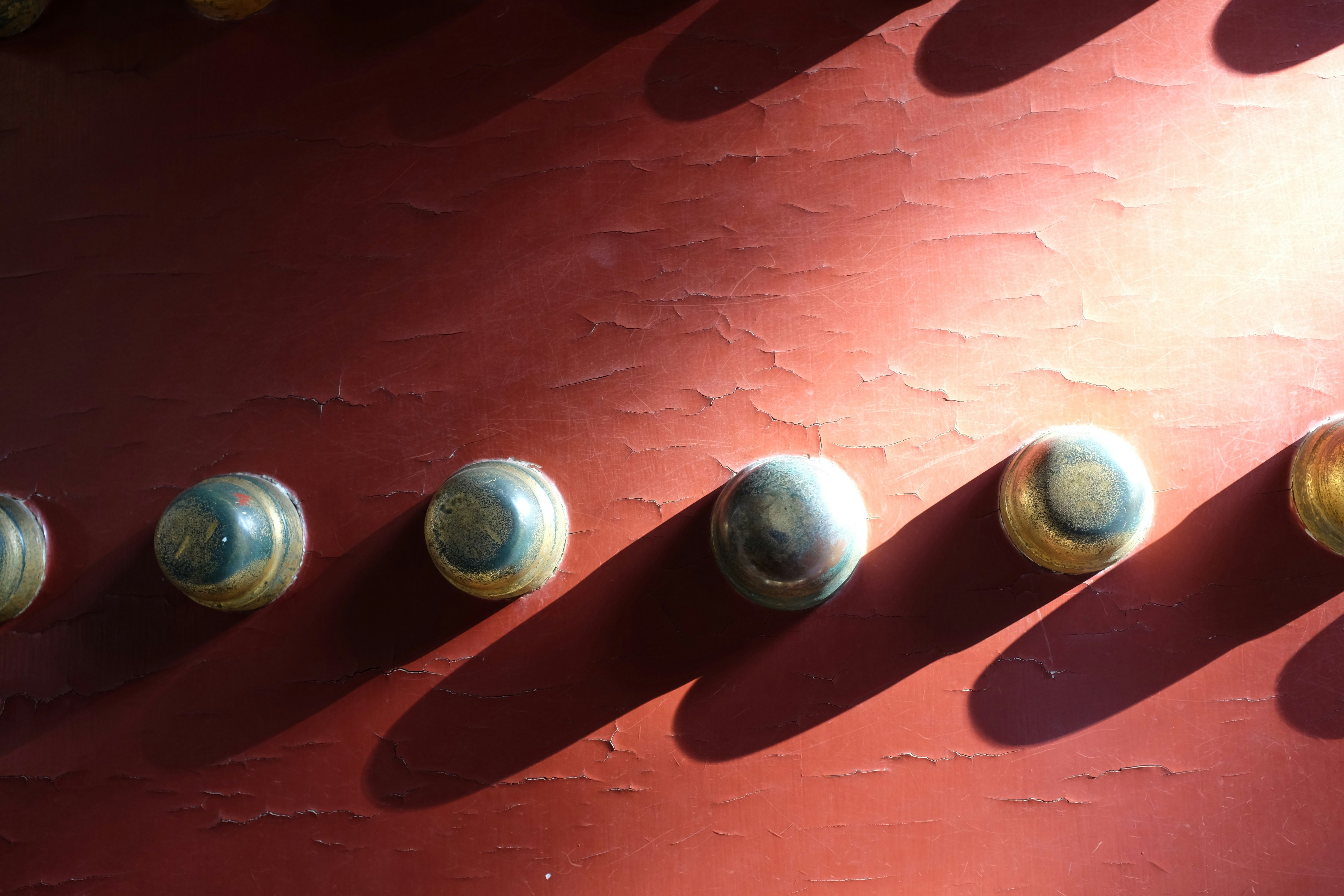 Row of metal studs on a red surface