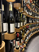 Bottles of wine displayed on a curved shelf.