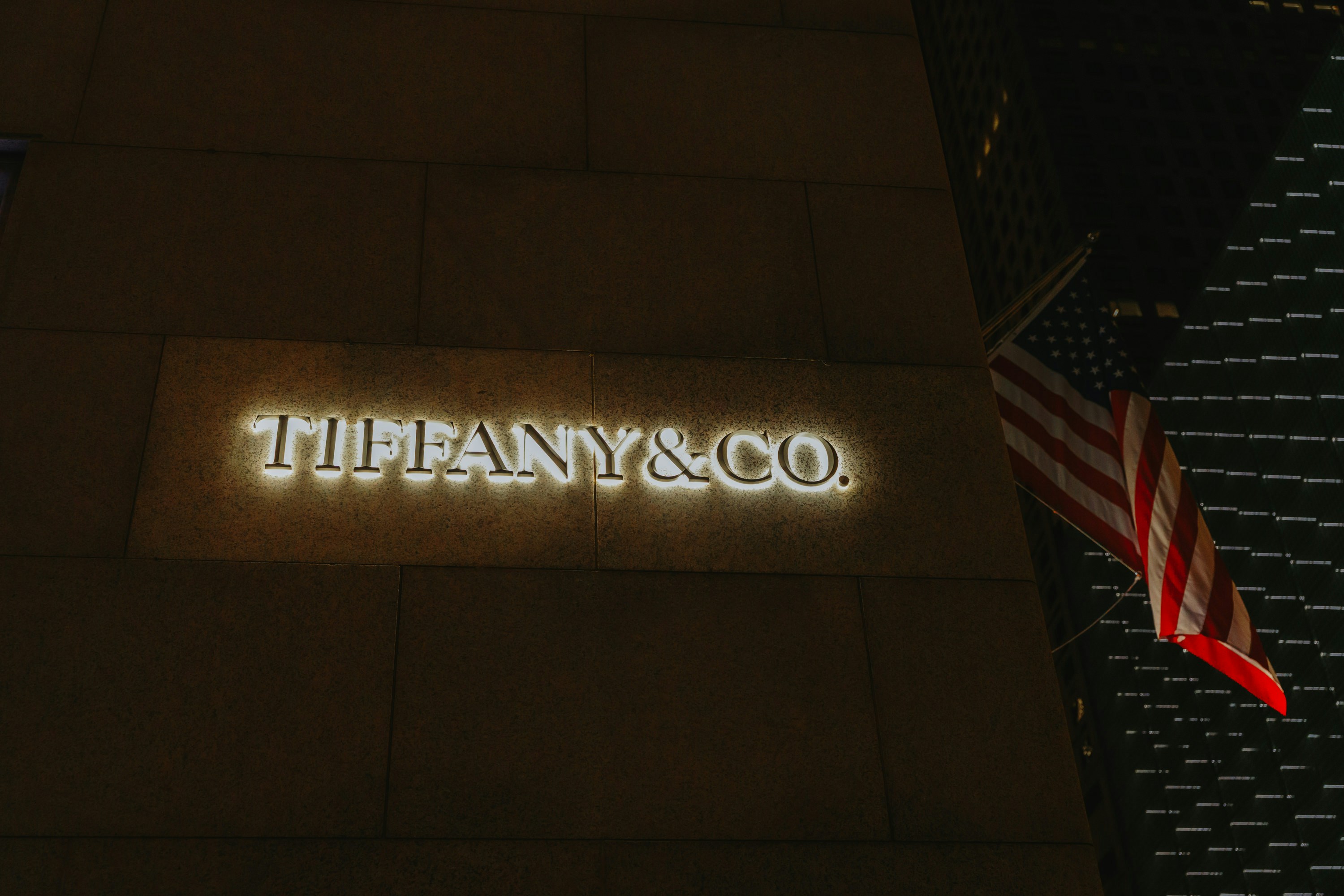 Cartel de tienda Tiffany & co. por la noche con la bandera americana