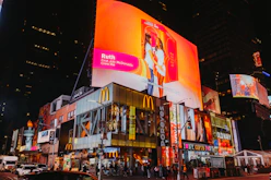 Times square buildings with bright illuminated billboards at night.