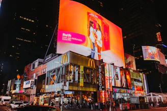 Times square buildings with bright illuminated billboards at night.