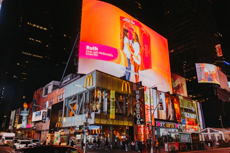Times square buildings with bright illuminated billboards at night.