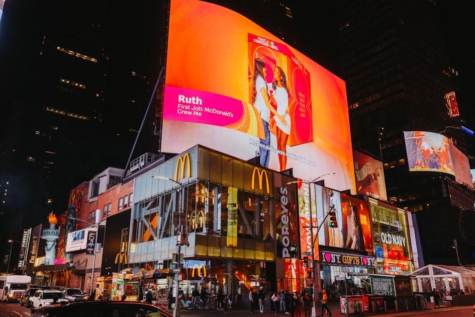 Times square buildings with bright illuminated billboards at night.