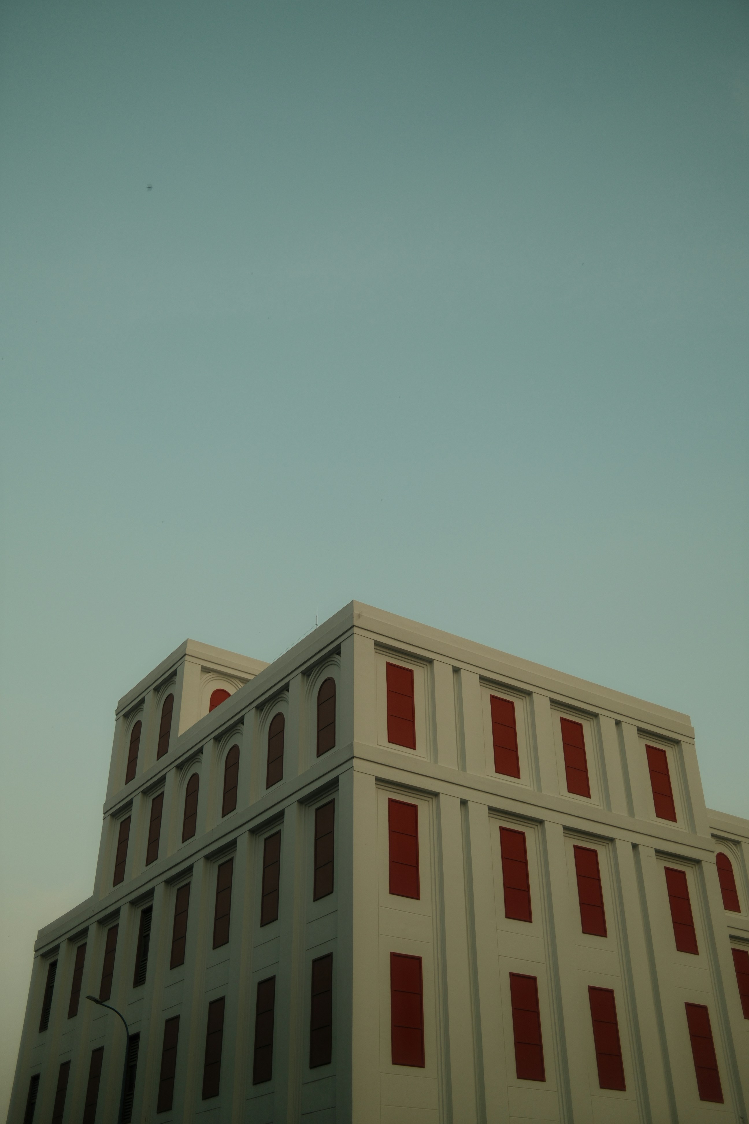 Edificio moderno con finestre rosse contro il cielo limpido