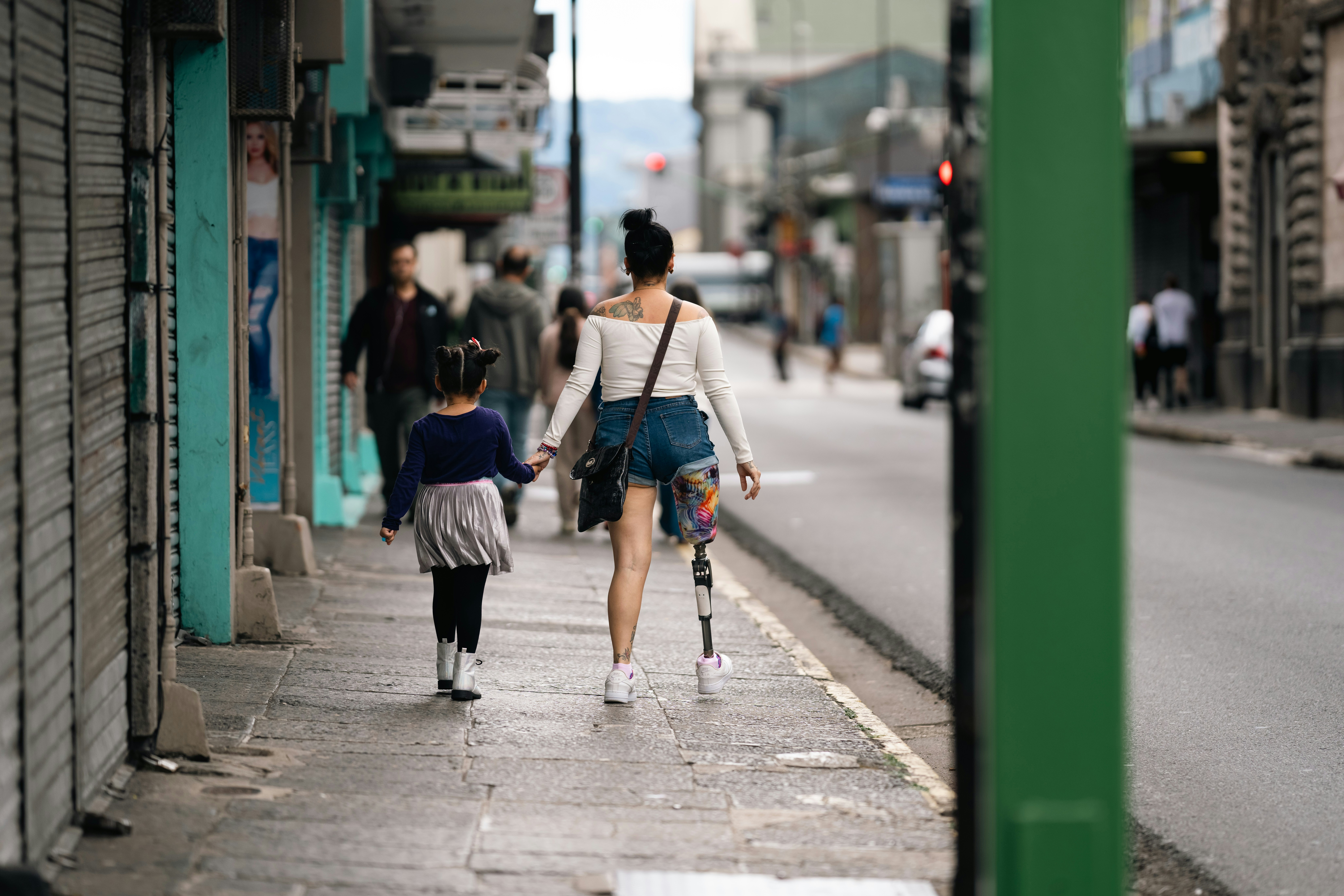 Woman with prosthetic leg walks with child