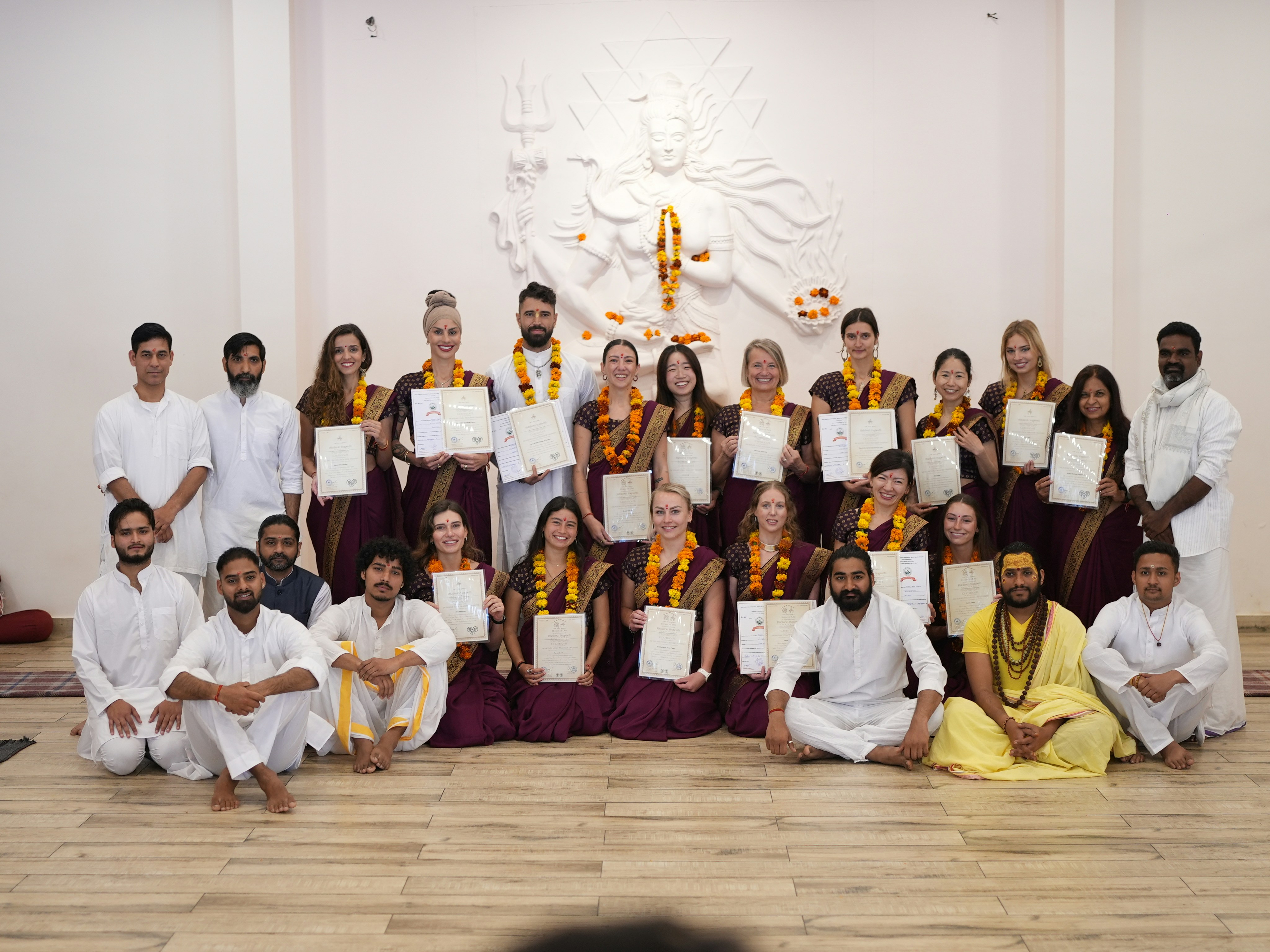 Group of people in traditional attire holding certificates