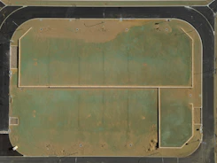 Aerial view of a dusty, green athletic field.