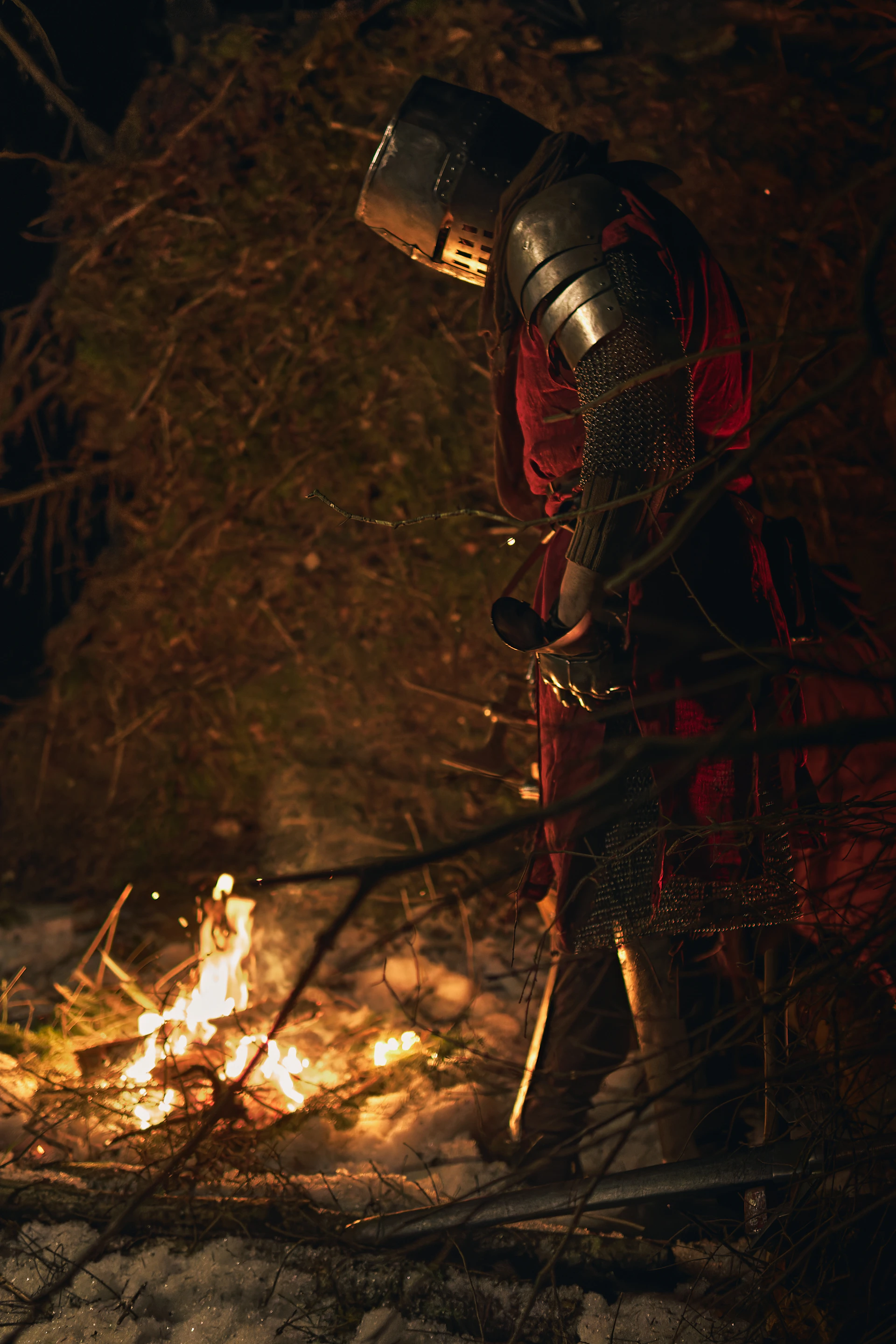 Knight in armor by a campfire at night