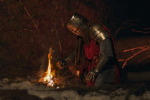Knight in armor by a campfire at night