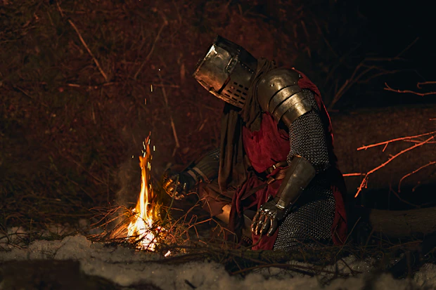 Knight in armor by a campfire at night