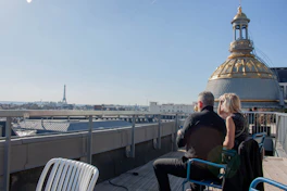 Couple enjoying a rooftop view of paris with eiffel tower.