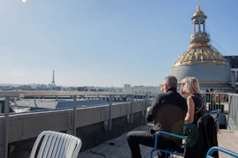 Couple enjoying a rooftop view of paris with eiffel tower.