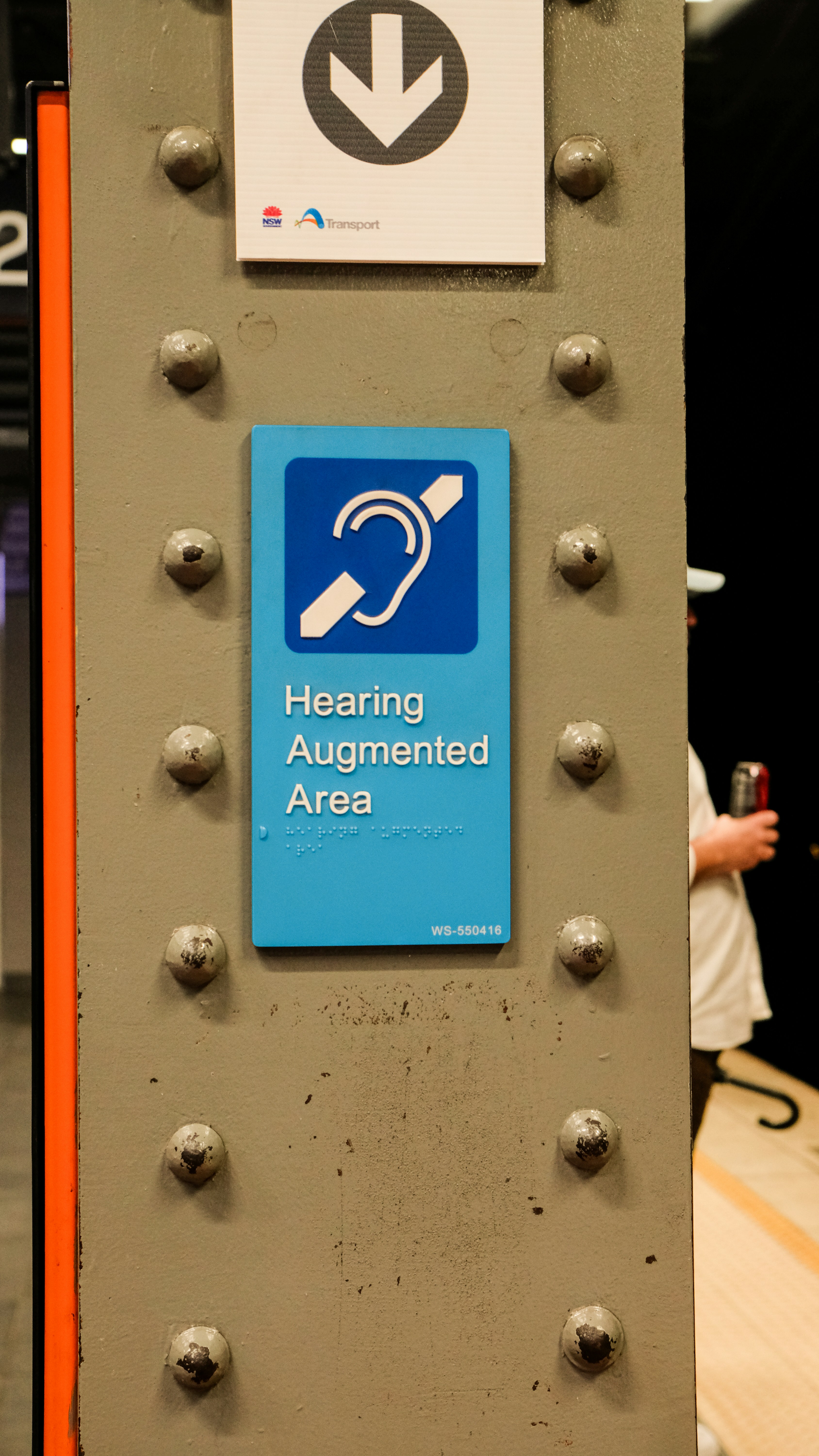 Placa de área aumentada com audição e símbolo de acessibilidade.