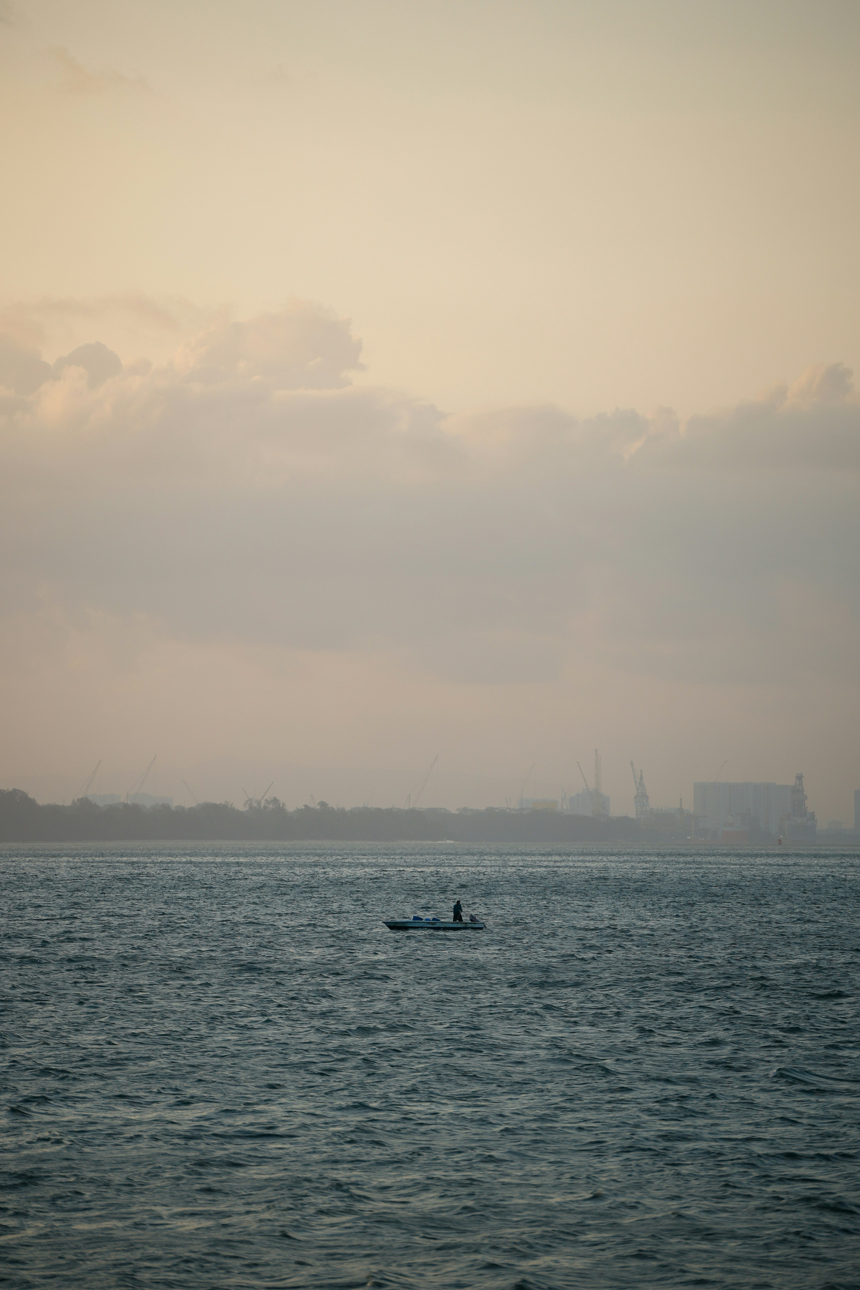 Uma pessoa rema um pequeno barco no oceano.