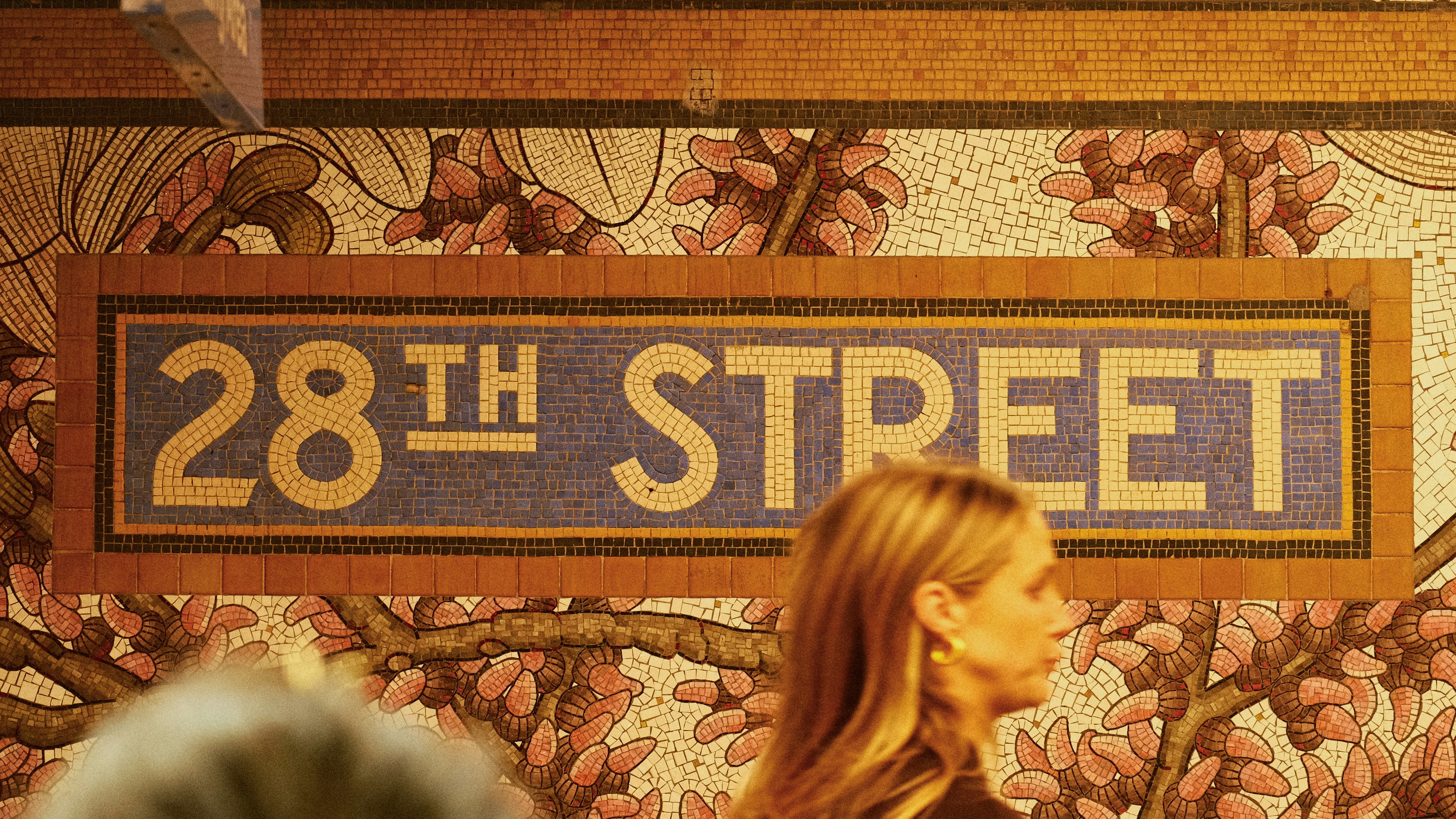 28th street subway station sign with floral wallpaper