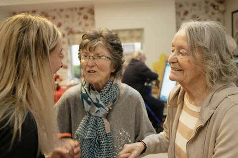 Three women talking and smiling in a room