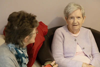 Two elderly women sitting and talking