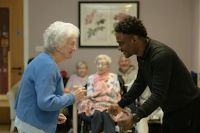 Elderly woman dances with a younger man
