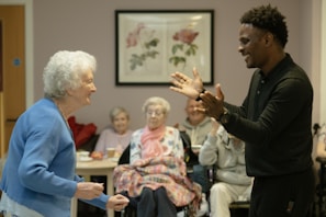 Man clapping hands with an elderly woman.