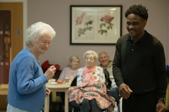 Carer sitting with elderly client at home
