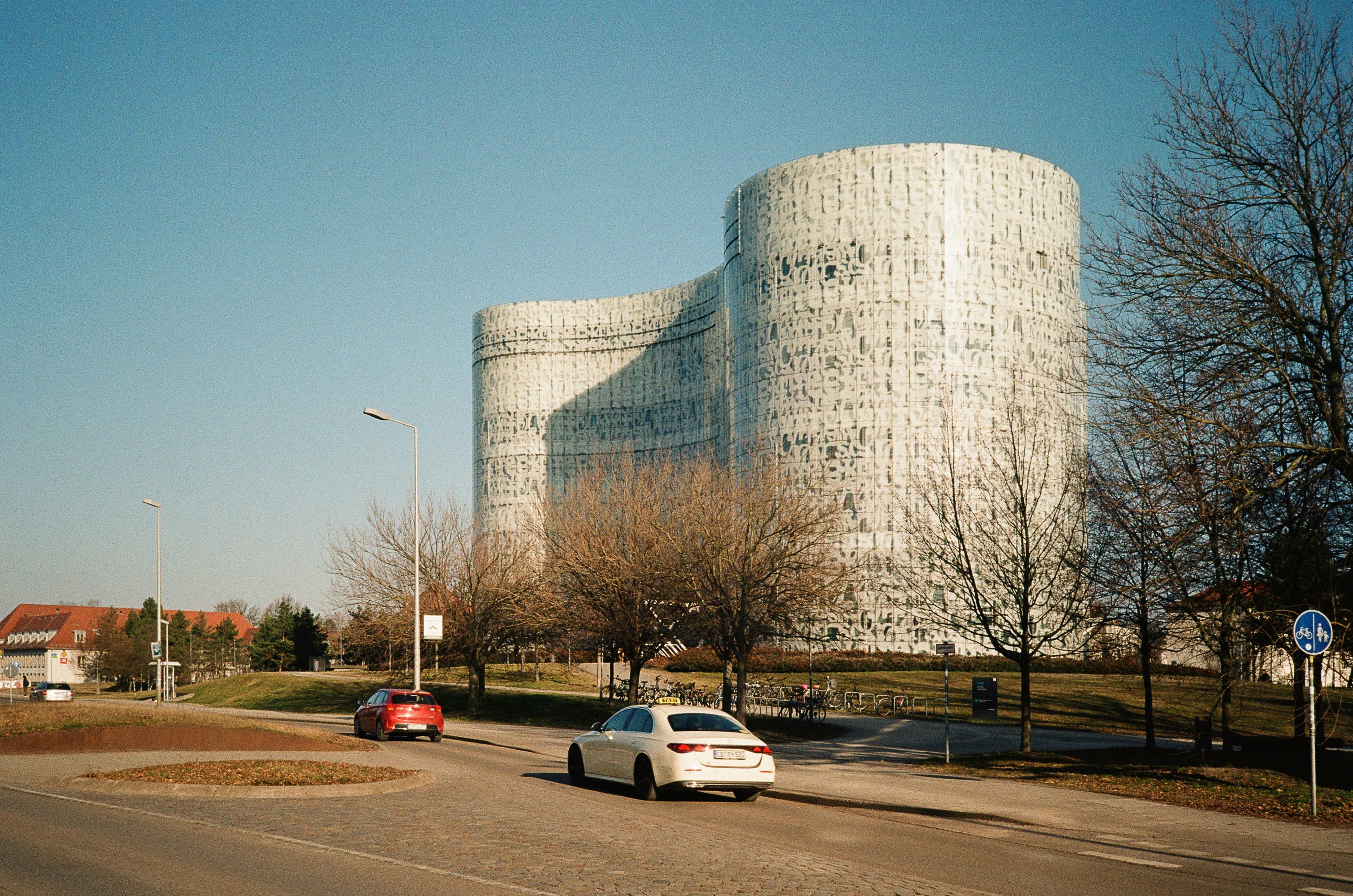Edificio moderno a forma curva con auto su strada