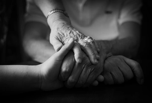 Two hands holding each other with care