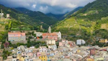 Colorful village nestled in a lush green mountain valley.