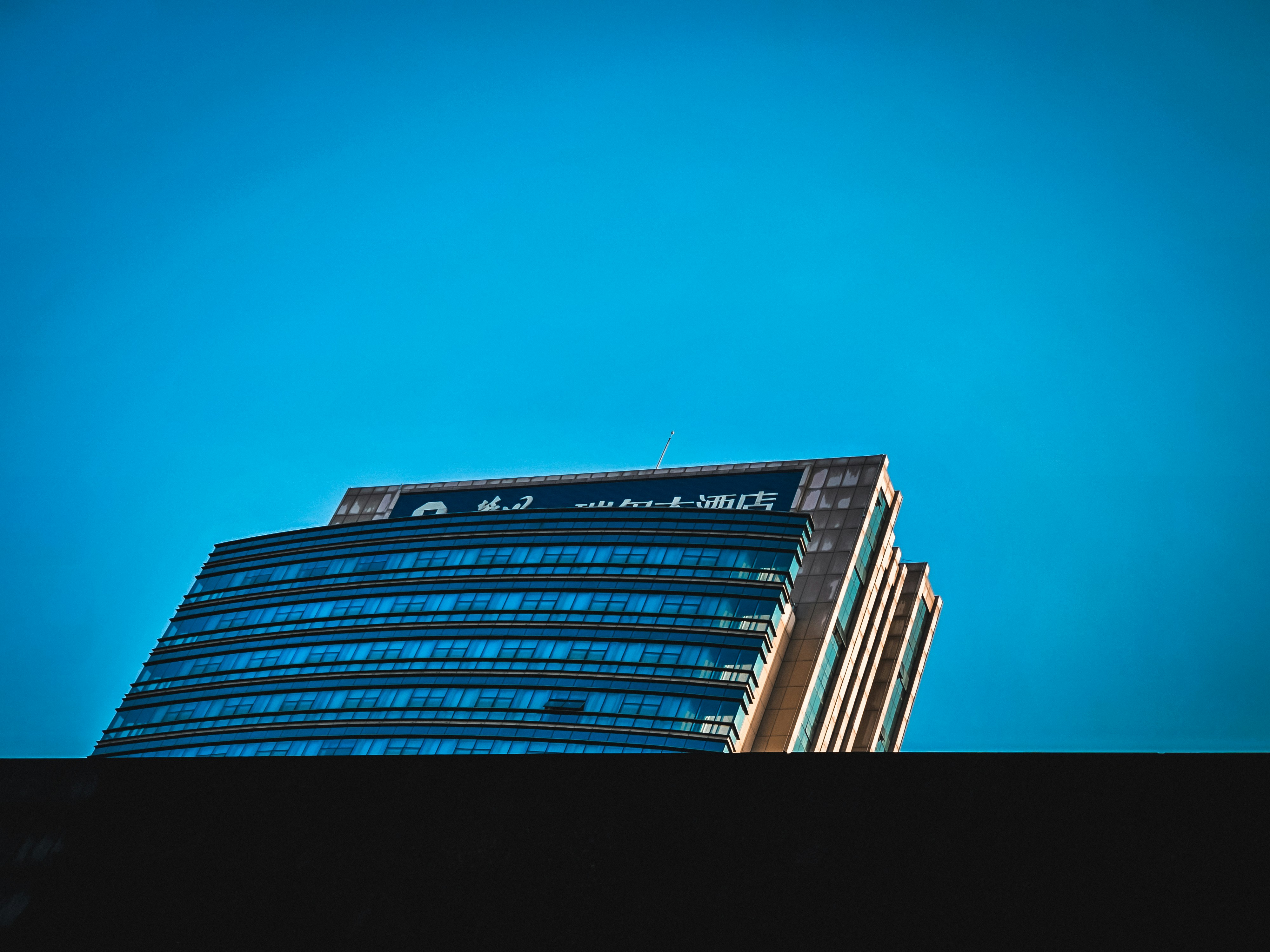 Moderner Glaswolkenkratzer vor klarem blauen Himmel