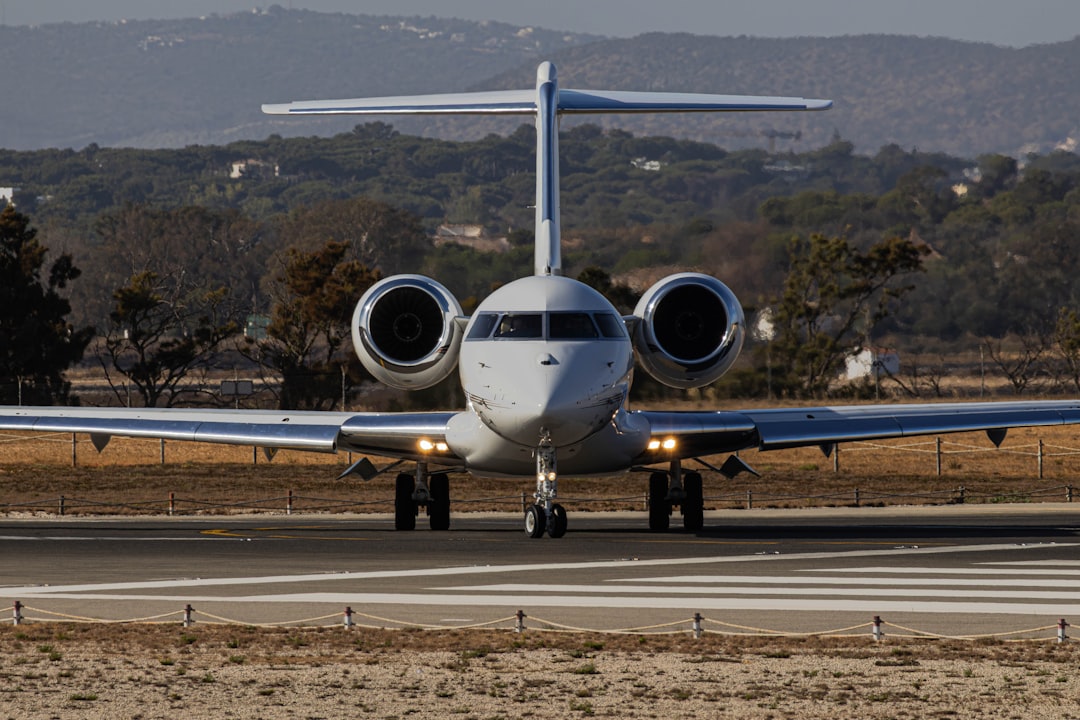 A white private jet taxiing on a runway