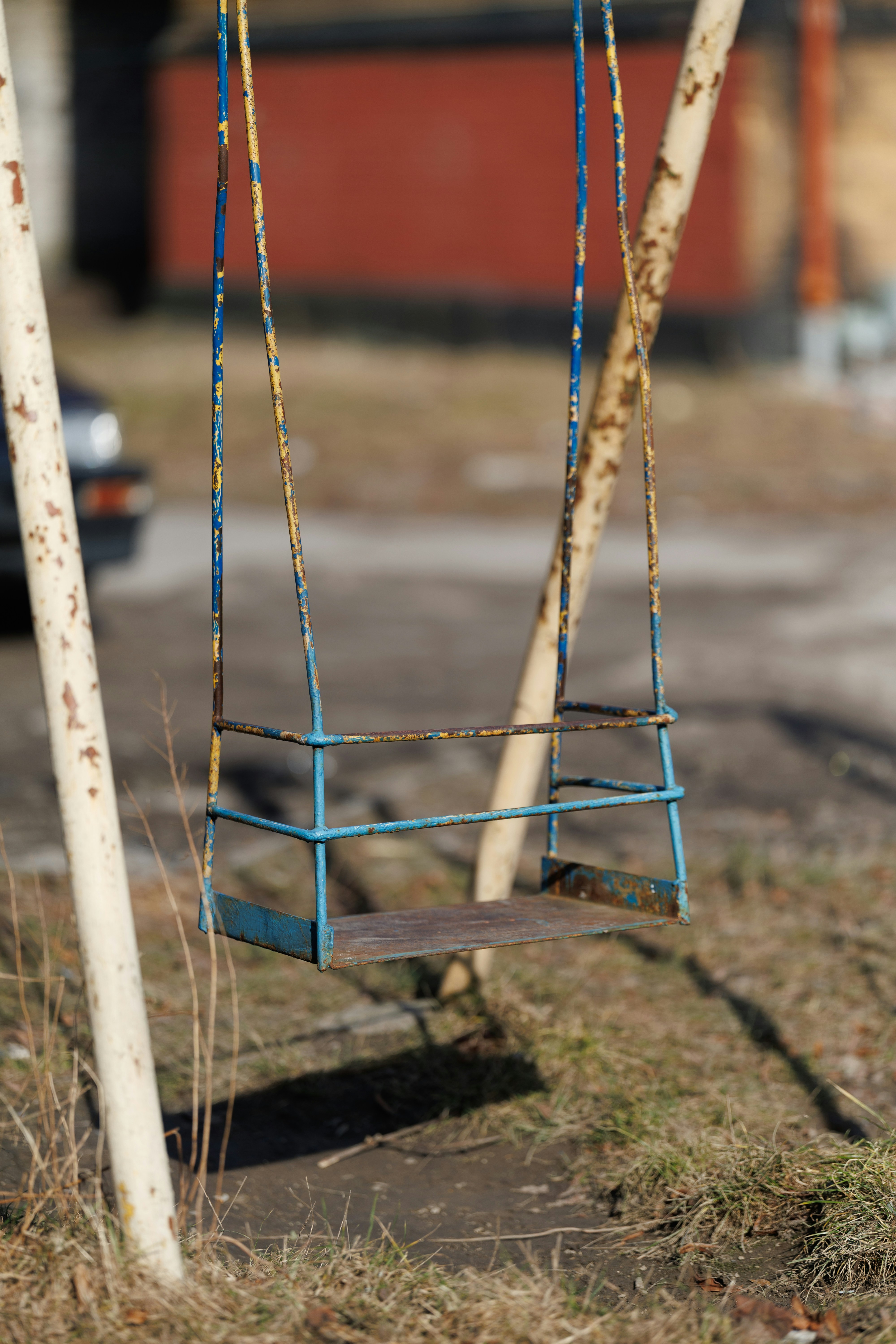 An old rusty swing set in an outdoor setting