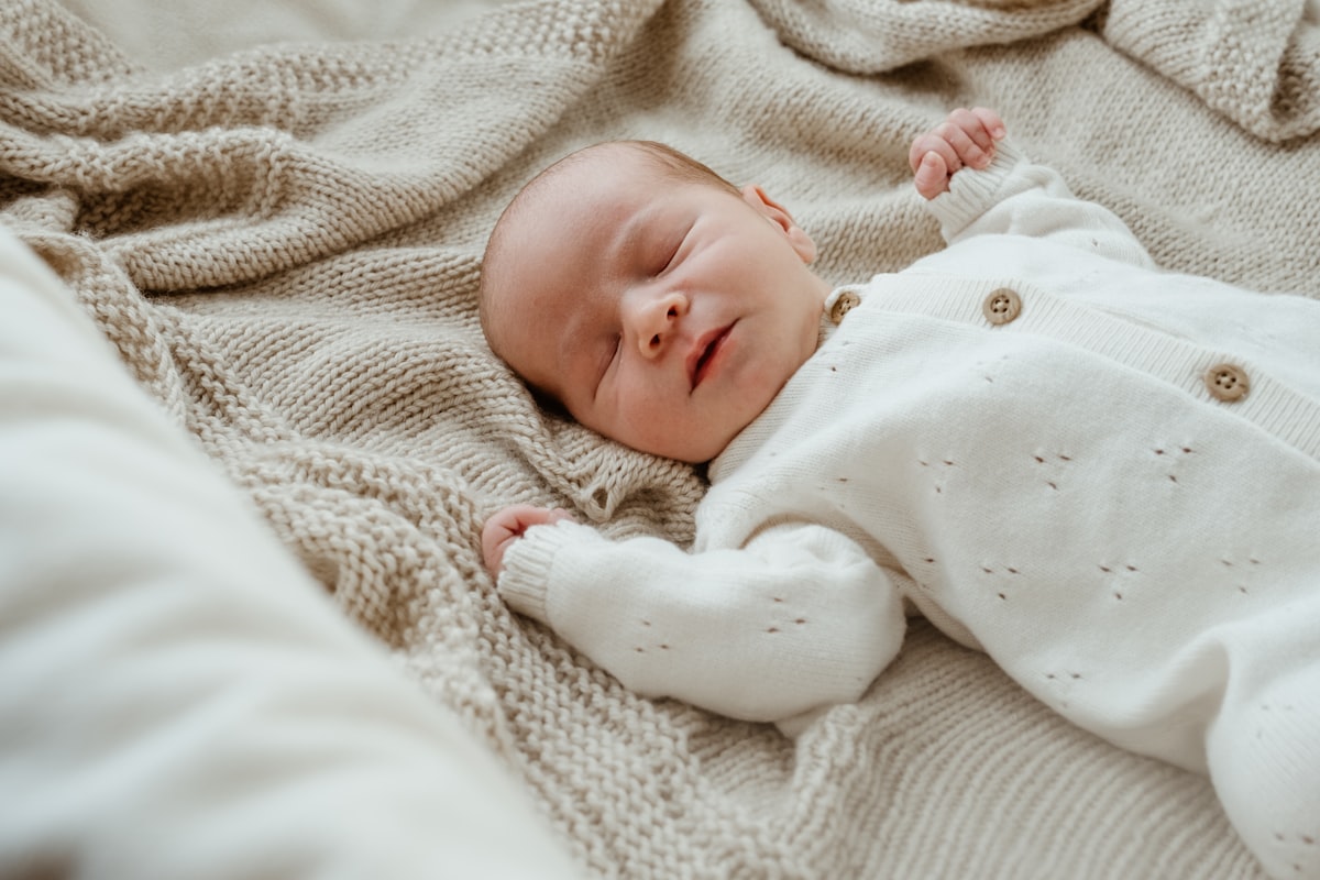 A newborn baby sleeping on a soft blanket