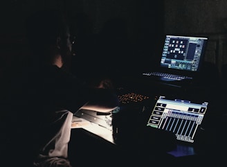 Person working on computer and audio equipment