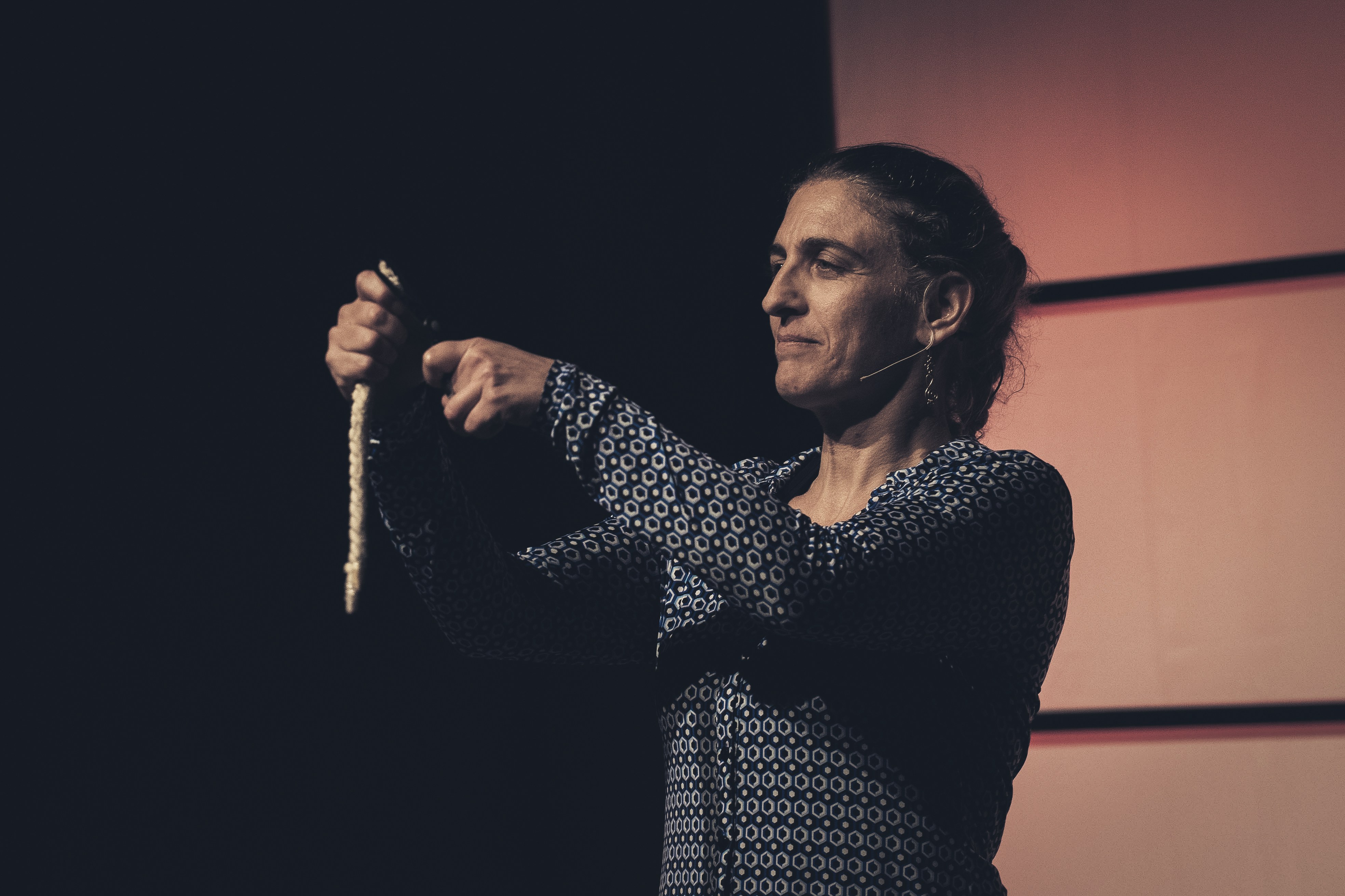 Frau, die einen langen Gegenstand hält und spricht