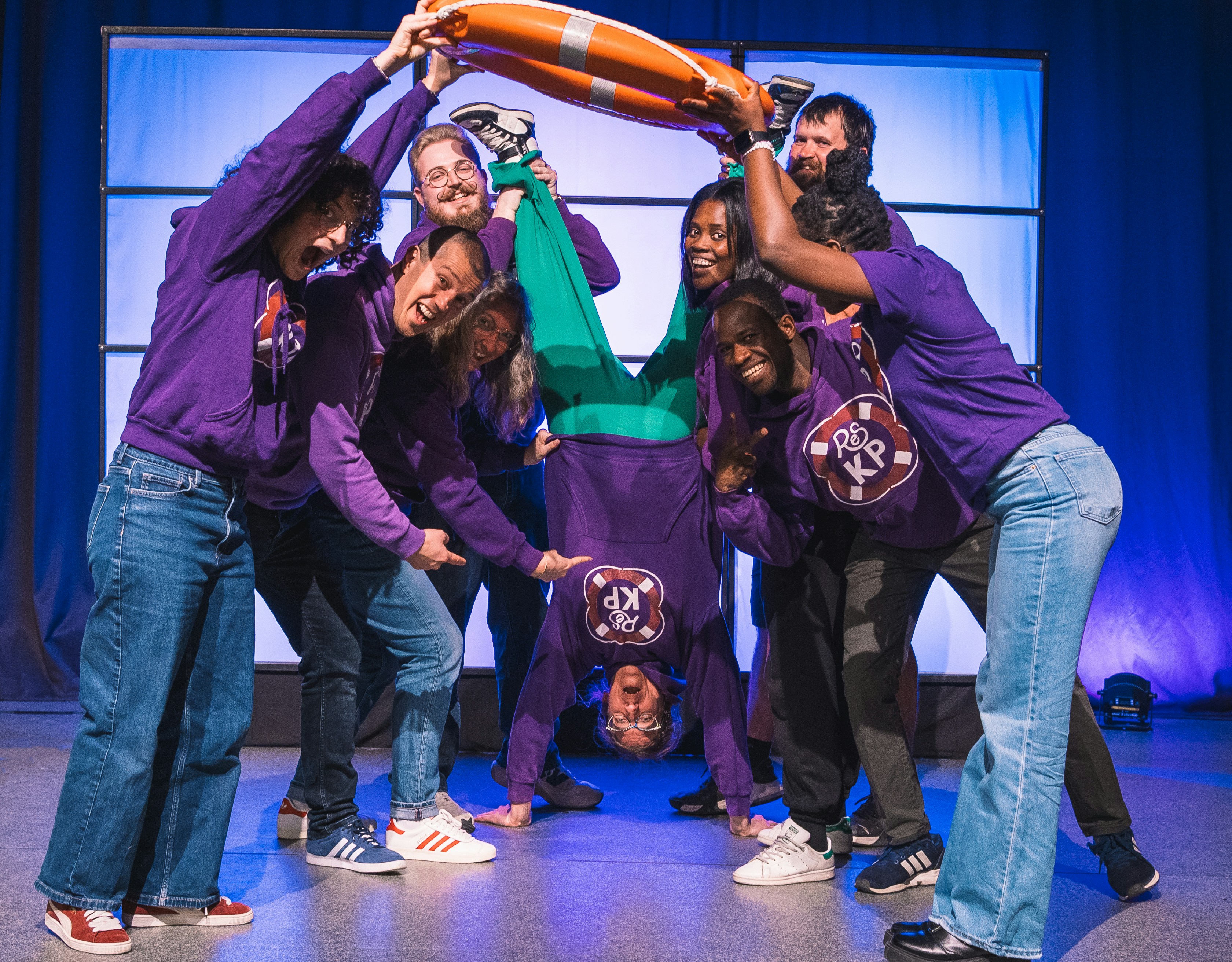 Group of people holding a person doing a handstand